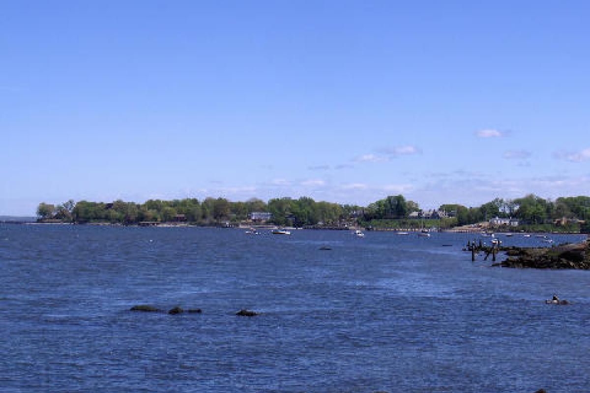 Photo of body of water with opposite side visible including houses and boats